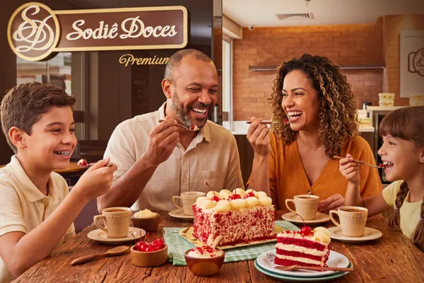 Família comemorando com bolo Sodiê Doces em uma das lojas da rede